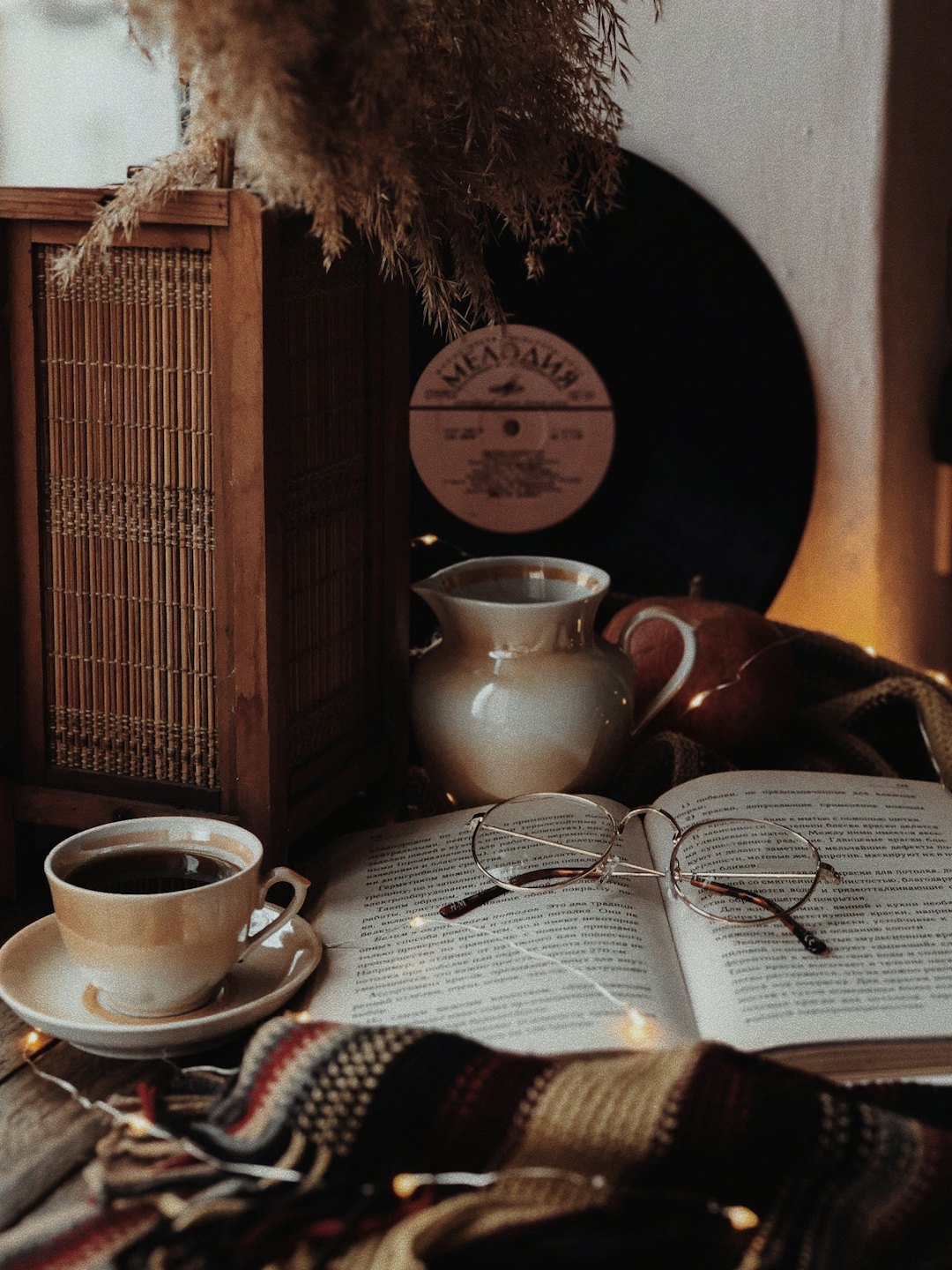 Libro aperto con occhiali e tazza di caffè su un tavolo di legno.